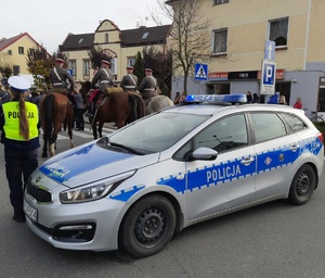 policjantka ruchu drogowego, radiowóz, w tle pułk ułanów na koniach w barwach ułanów małopolskich