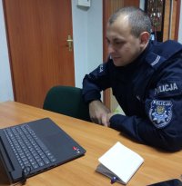 policjant przed komputerem typu laptop