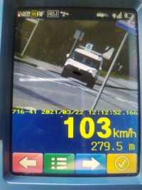 zdjęcie ekranu ręcznego miernika prędkości z widocznymi parametrami pomiaru, na zdjęciu jezdnia, pojazd osobowy koloru białego