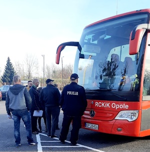 policjant i ludzie przed krwiobusem