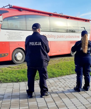 policjant i policjantka przed krwiobusem