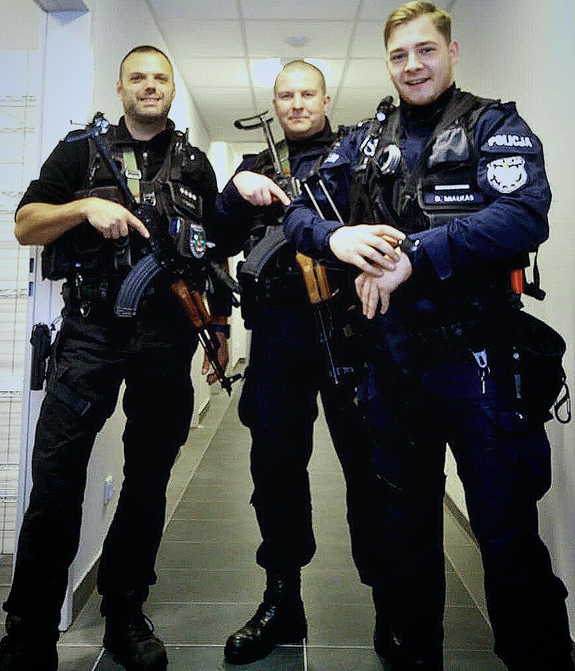 trzej policjanci stojący w korytarzu komendy powiatowej policji w Krapkowicach, umundurowani, trzymający broń długa w rękach