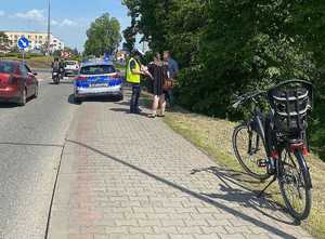 chodnik, jezdnia, rower, policjantka wykonująca czynności na miejscu wypadku, kobieta i mężczyzna, samochody vosobowe