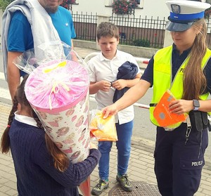 policjanta rozdaje odblaski dzieciom