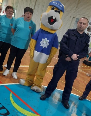 policjanci i seniorzy na hali sportowej, również z maskotka policyjną królikiem policusiem