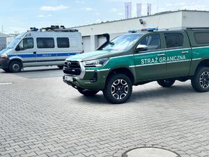 Obraz przedstawia funkcjonariuszy Policji oraz Straży Granicznej