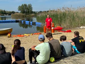 Obrazy przedstawiają uczestników prelekcji bezpieczeństwa nad wodą.