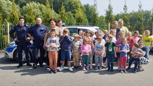 Na fotografii znajduje się grupa przedszkolaków wraz z Policjantami oraz radiowóz.
