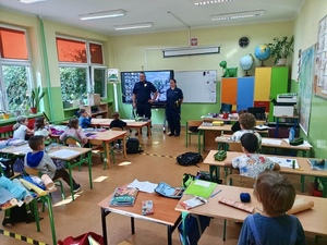 Zdjęcie przedstawia funkcjonariuszy przeprowadzający spotkanie w ramach akcji Bezpieczna Droga do Szkoły