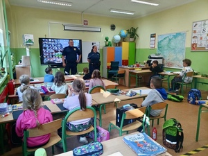 Zdjęcie przedstawia funkcjonariuszy przeprowadzający spotkanie w ramach akcji Bezpieczna Droga do Szkoły