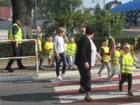 Dzieci, opiekunki i policjanci na spacerze, przechodzą przez przejście dla pieszych