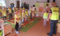 Przedszkole, dzieci tańczą policjantka ogląda występ