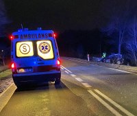 karetka pogotowia, wrak samochodu i policjant pracujący przy oględzinach wraku