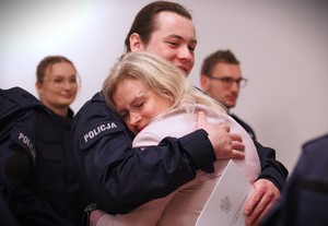 Zdjęcie przedstawia policjanta, który ściska kobietę.